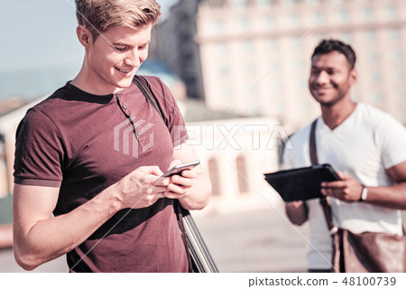 Cheerful student typing positive message Cheerful student typing positive message 48100739