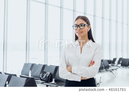 Portrait of smiling attractive business woman in airport hall. Copy space Portrait of smiling attractive business woman in airport hall. Copy space 48101781
