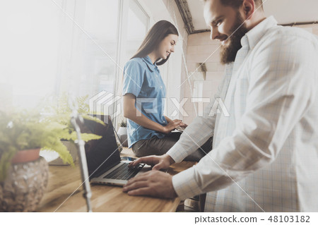 Young man and woman work at laptops while sitting Young man and woman work at laptops while sitting 48103182
