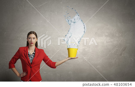 Girl pouring water from bucket 48103654