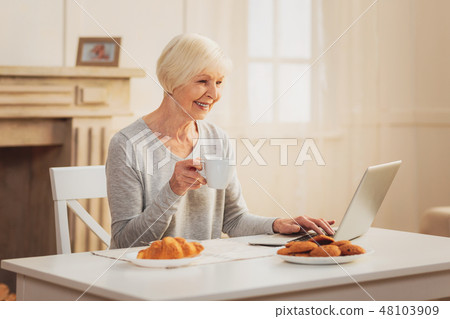 Grandmother smiling while chatting via internet with grandchildren 48103909