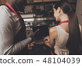 Barista man and woman looking at a laptop 48104039