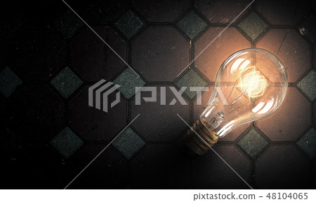 Light bulb on brick surface 48104065