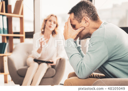 Stressed man feeling troubled speaking to therapist 48105049