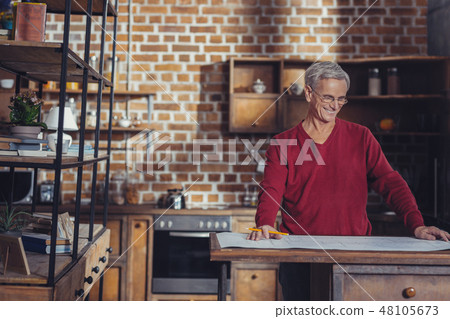 Cheerful aged architect smiling while working at the project 48105673