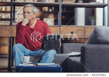 Serious pensioner putting his chin oh a fist while thinking Serious pensioner putting his chin oh a fist while thinking 48105681