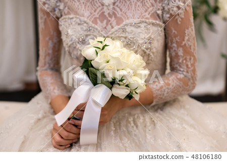 A beautiful bride holding a bouquet of pretty flowers A beautiful bride holding a bouquet of pretty flowers 48106180