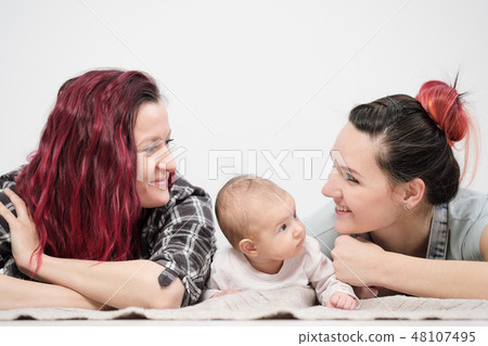Two young women with a baby on a white background. Same-sex marriage and adoption, homosexual 48107495