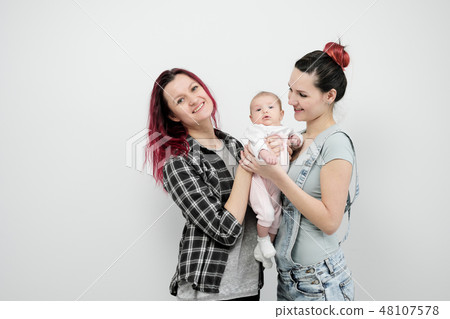 Two young women with a baby on a white background. Same-sex marriage and adoption, homosexual 48107578