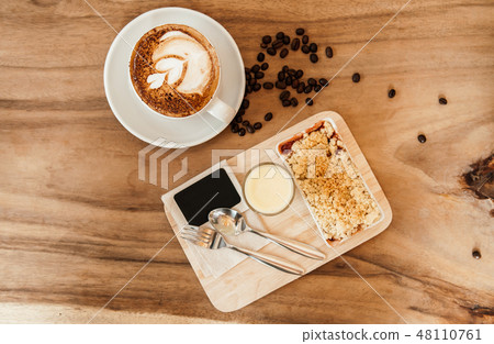 Apple crumble on wood tray with hot latte coffee Apple crumble on wood tray with hot latte coffee 48110761