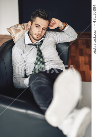 Handsome hipster man relaxing in sofa Handsome hipster man relaxing in sofa 48110894