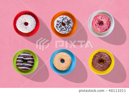 colorful donuts with different flavors on plates colorful donuts with different flavors on plates 48111011