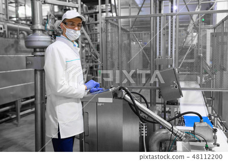 technologist taking necessary notes while standing at production department of dairy factory technologist taking necessary notes while standing at production department of dairy factory 48112200
