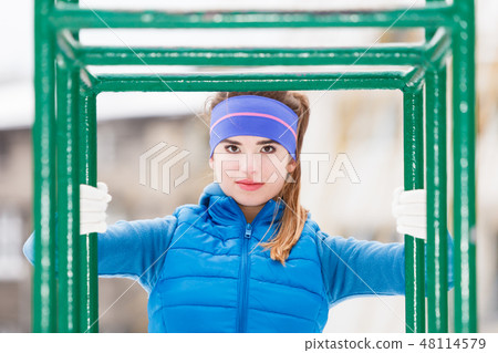 Woman wearing sportswear urban exercising outside during winter 48114579