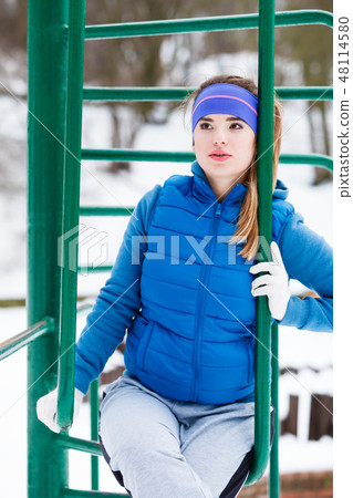 Woman wearing warm sportswear relaxing after exercising Woman wearing warm sportswear relaxing after exercising 48114580