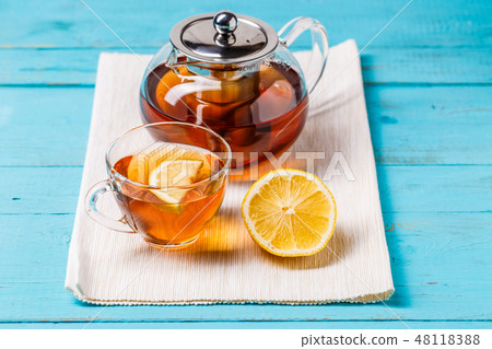 Glass cup of tea with lemon and glass teapot. 48118388
