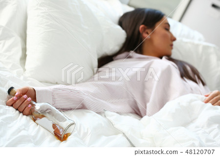 Young woman lying in bed deadly drunken Young woman lying in bed deadly drunken 48120707