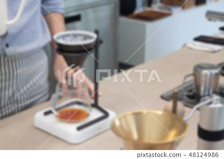 Barista with drip coffee, blurred background Barista with drip coffee, blurred background 48124986