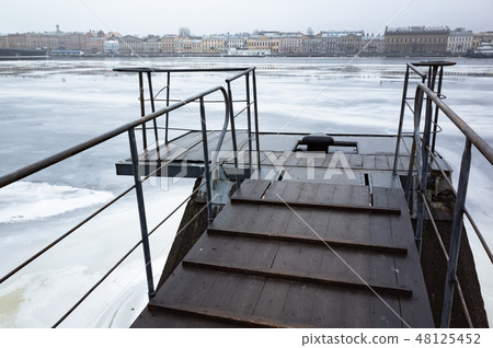 Wet wooden pier on Neva River 48125452