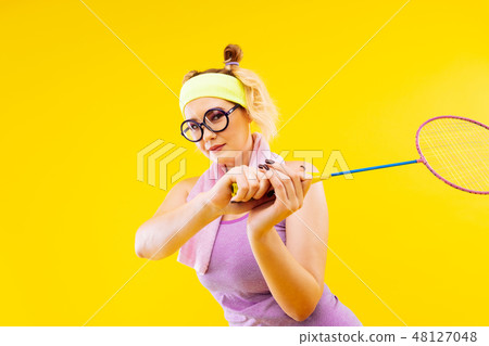 Blonde-haired woman wearing glasses holding tennis racket Blonde-haired woman wearing glasses holding tennis racket 48127048
