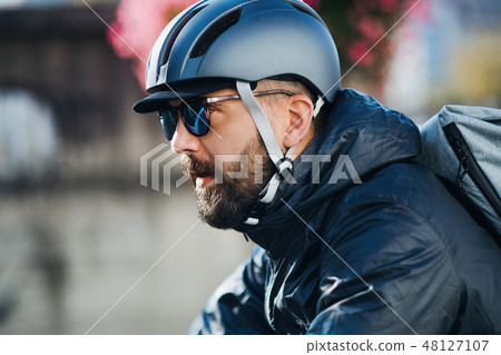 Male courier with bicycle delivering packages in city. 48127107
