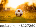 Soccer football on green grass field under rain 48127260