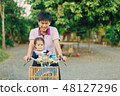 baby ride  bicycle with her father 48127296