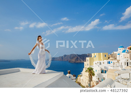 Bride in white dress on the high roof of Santorin Bride in white dress on the high roof of Santorin 48127392