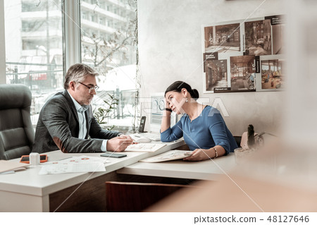 Grey-haired serious man in eyeglasses and his colleague looking serious 48127646