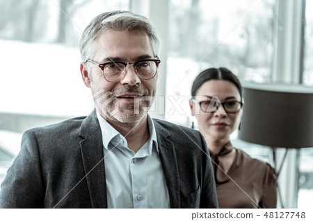 Brunette adult businesswoman in a brown satin blouse smiling 48127748