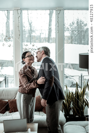 Tall grey-haired handsome man in a blue shirt and a dark-haired woman feeling wonderful 48127915