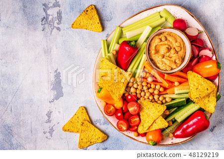 Hummus with various fresh raw vegetables. Hummus with various fresh raw vegetables. 48129219