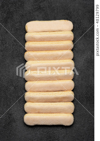 Italian Savoiardi ladyfingers Biscuits on dark concrete backgound Italian Savoiardi ladyfingers Biscuits on dark concrete backgound 48129799