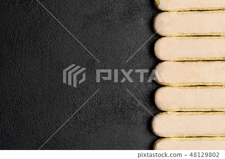 Italian Savoiardi ladyfingers Biscuits on dark concrete backgound Italian Savoiardi ladyfingers Biscuits on dark concrete backgound 48129802