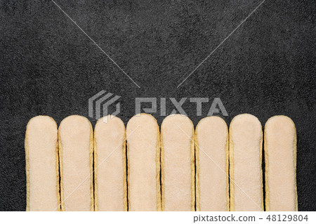 Italian Savoiardi ladyfingers Biscuits on dark concrete backgound Italian Savoiardi ladyfingers Biscuits on dark concrete backgound 48129804