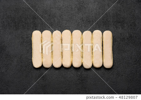 Italian Savoiardi ladyfingers Biscuits on dark concrete backgound Italian Savoiardi ladyfingers Biscuits on dark concrete backgound 48129807