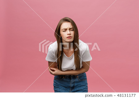Young caucasian woman over isolated background with hand on stomach because indigestion, painful Young caucasian woman over isolated background with hand on stomach because indigestion, painful 48131177