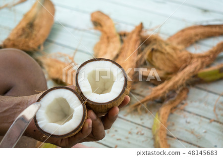 Halved inner coconut in asian man's hands Halved inner coconut in asian man's hands 48145683