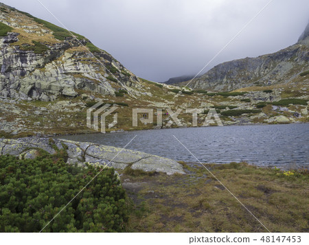 Pleso nad Skokom, beautiful mountain lake in Mlynicka Dolina Valley with hiking peoples on footpath 48147453