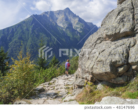 Senior tourist woman hiking at the beautiful nature trail at high tatra mountains in slovakia Senior tourist woman hiking at the beautiful nature trail at high tatra mountains in slovakia 48147696