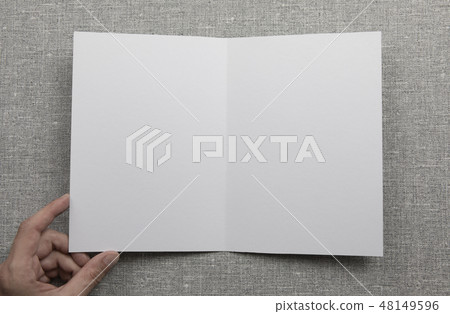 Mens hands holding empty white booklet Mens hands holding empty white booklet 48149596