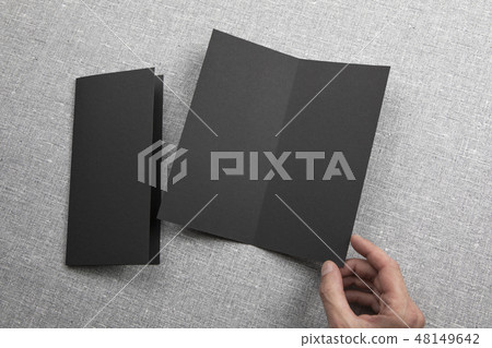 Mens hands holding empty black booklet Mens hands holding empty black booklet 48149642