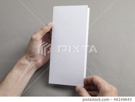 Mens hands holding white booklet Mens hands holding white booklet 48149643