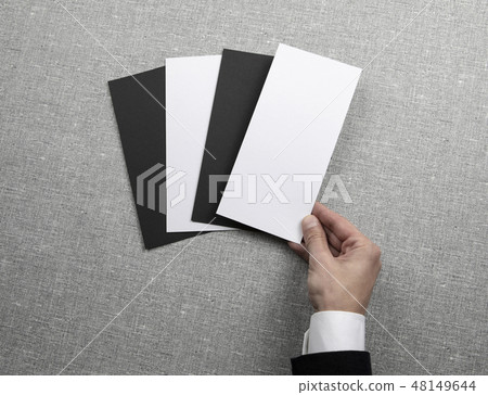 Mens hand holding empty white and black flyers Mens hand holding empty white and black flyers 48149644