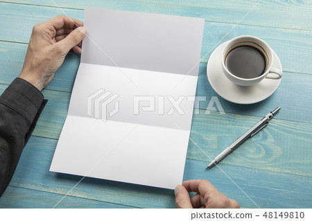 Mens hands holding white booklet 48149810