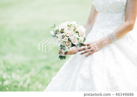 Bride holding big and beautiful wedding bouquet with flowers Bride holding big and beautiful wedding bouquet with flowers 48149886