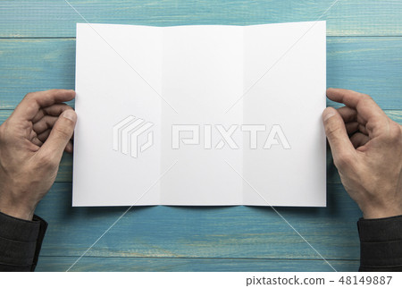 Mens hands holding white booklet Mens hands holding white booklet 48149887