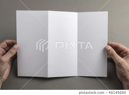 Mens hands holding white booklet Mens hands holding white booklet 48149888