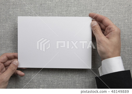Mens hands holding empty white letterhead Mens hands holding empty white letterhead 48149889