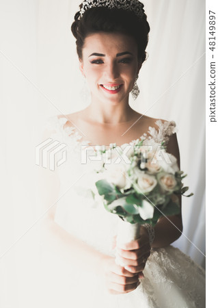 Gorgeous bride in robe posing and preparing for the wedding ceremony face in a room 48149897
